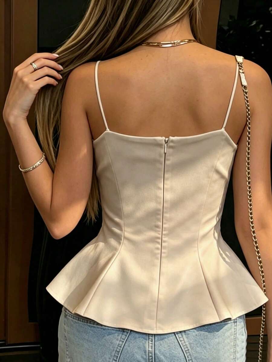 A sleeveless cropped camisole top featuring thin spaghetti straps, a slim fit bodice, and a subtle flared hemline.