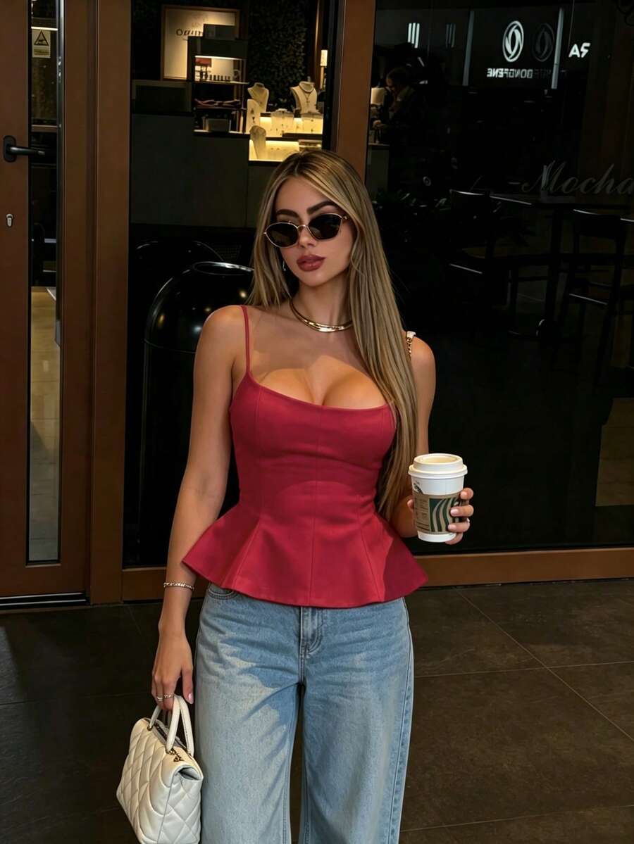 A sleeveless cropped camisole top featuring thin spaghetti straps, a slim fit bodice, and a subtle flared hemline.