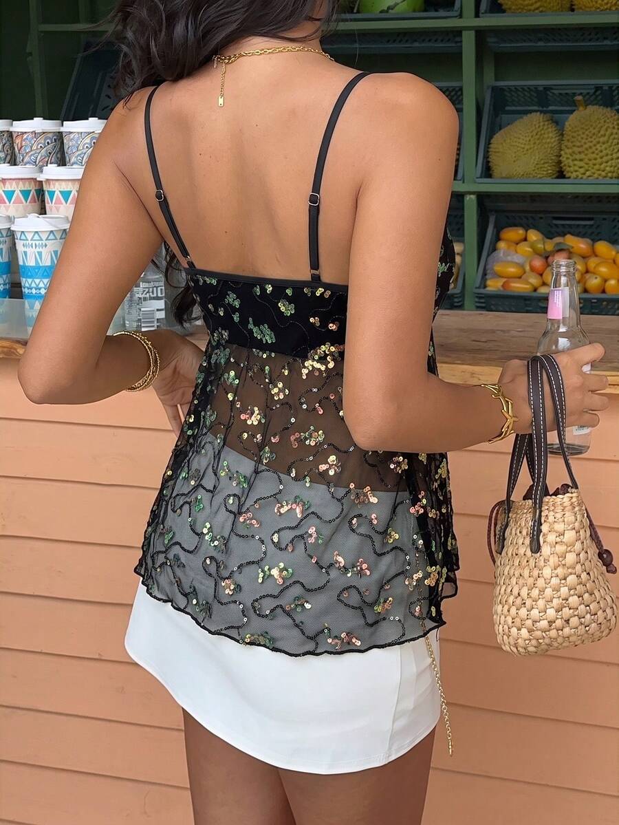 Women's black sequin lace patchwork camisole top featuring thin spaghetti straps, contrast lace trim, and an asymmetrical ruffle hem with knot details.