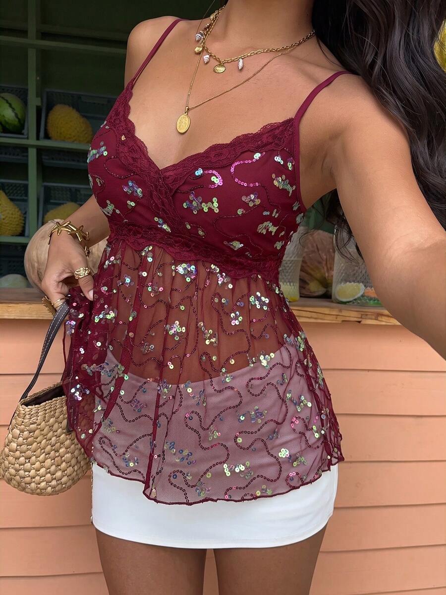 Women's black sequin lace patchwork camisole top featuring thin spaghetti straps, contrast lace trim, and an asymmetrical ruffle hem with knot details.