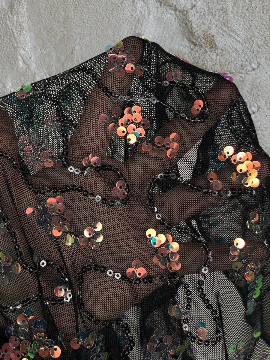 Women's black sequin lace patchwork camisole top featuring thin spaghetti straps, contrast lace trim, and an asymmetrical ruffle hem with knot details.