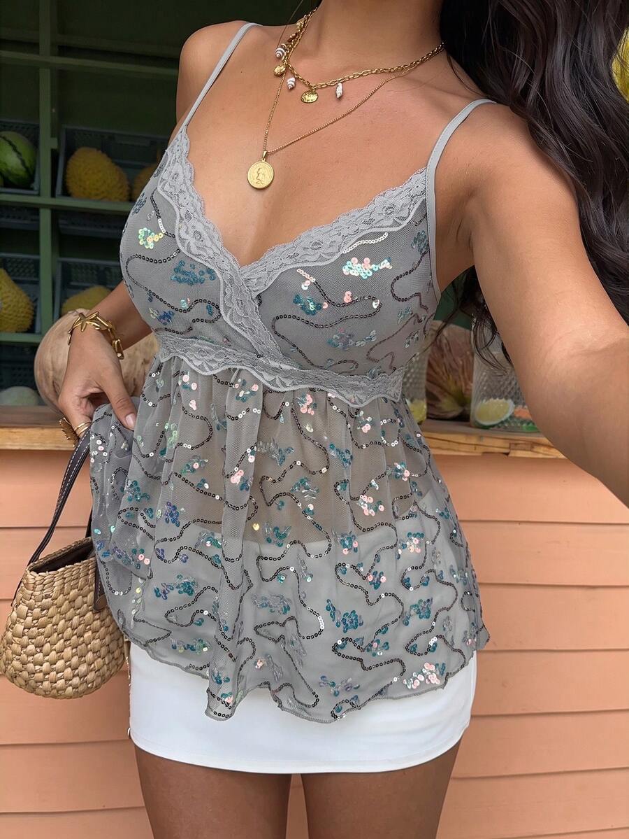Women's black sequin lace patchwork camisole top featuring thin spaghetti straps, contrast lace trim, and an asymmetrical ruffle hem with knot details.