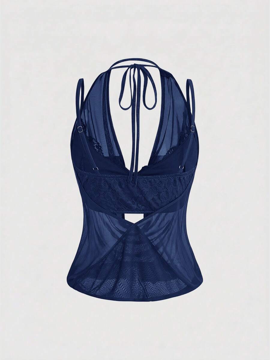 Women wearing a black draped backless halter crop top layered over a boned lace camisole.