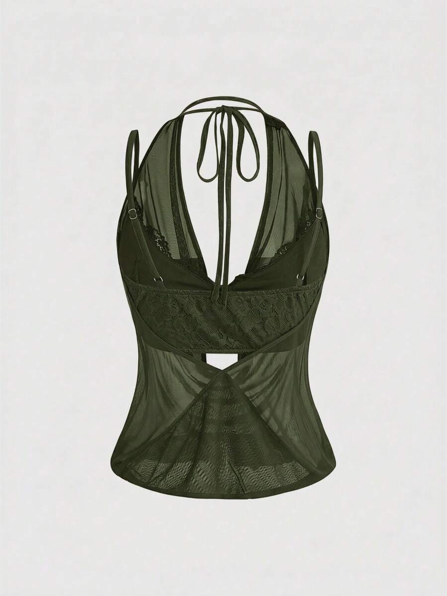 Women wearing a black draped backless halter crop top layered over a boned lace camisole.