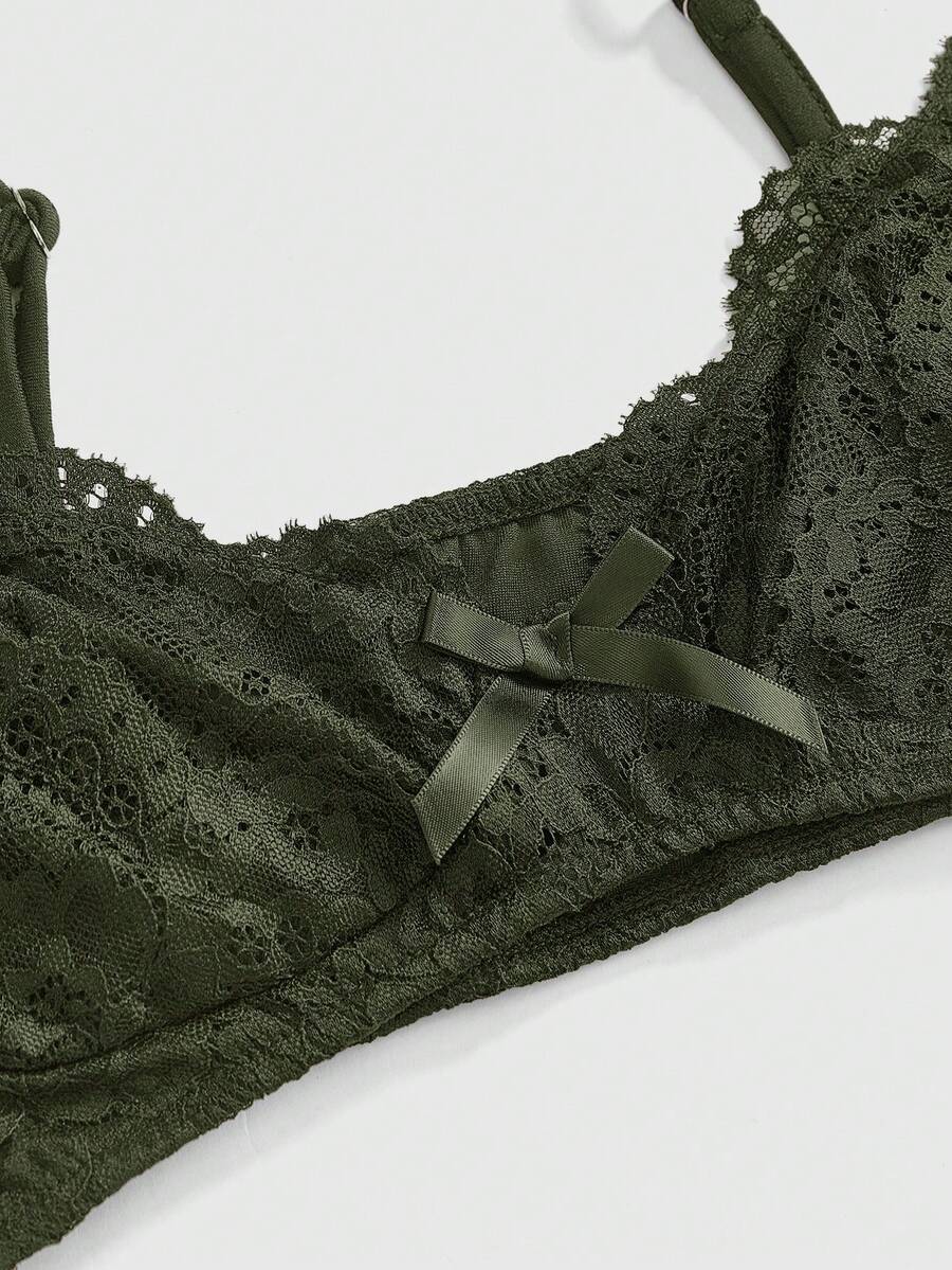 Women wearing a black draped backless halter crop top layered over a boned lace camisole.