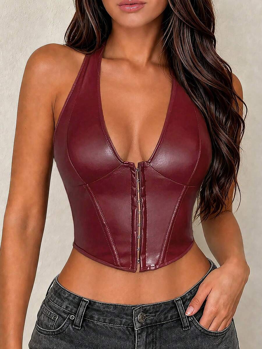 White Y2K PU leather camisole crop top featuring front grommet eyelet lace-up detailing, V-neckline, and backless silhouette on a model.