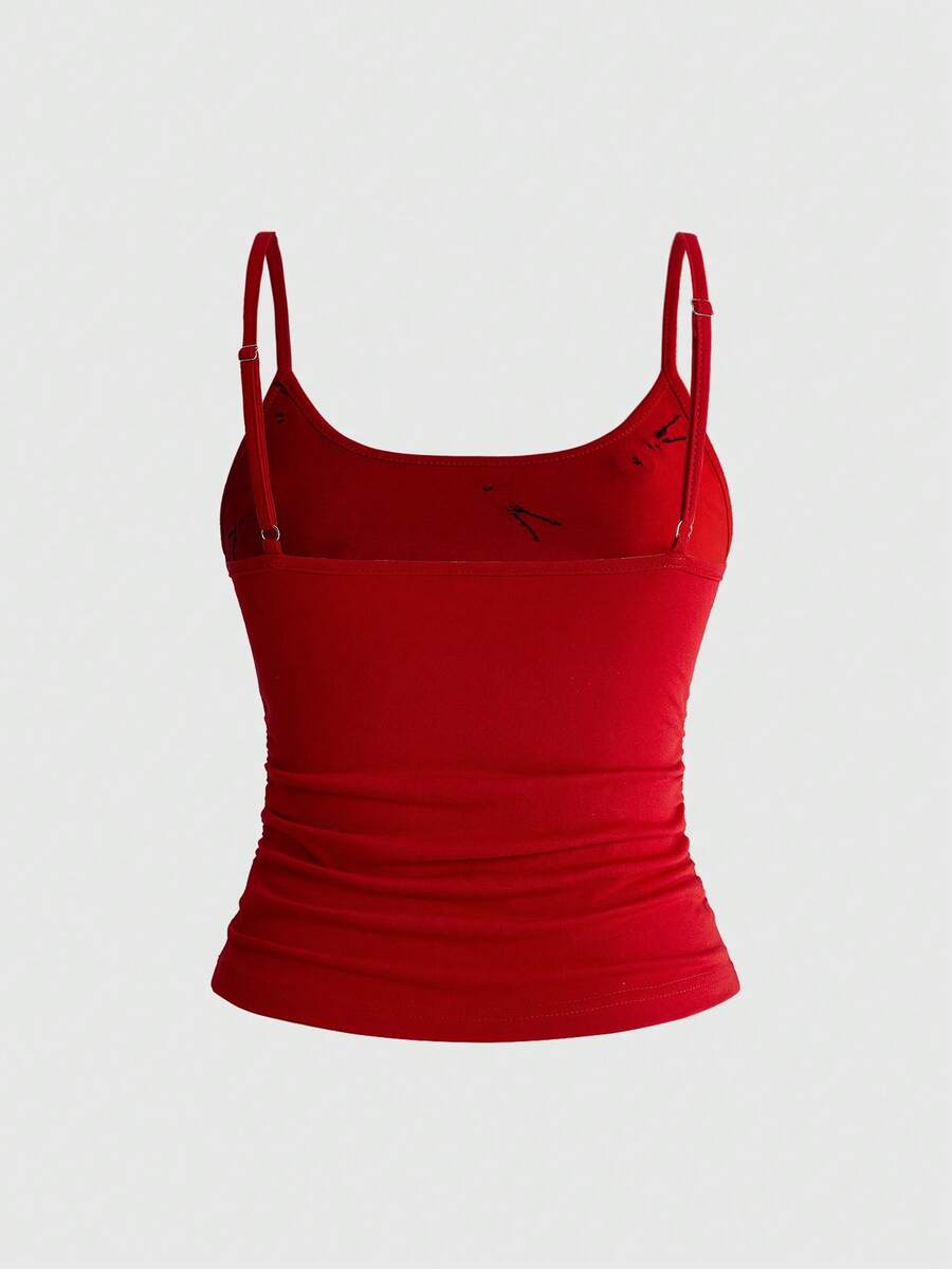 Woman wearing a black backless halter tank top with criss-cross details and textured knit fabric