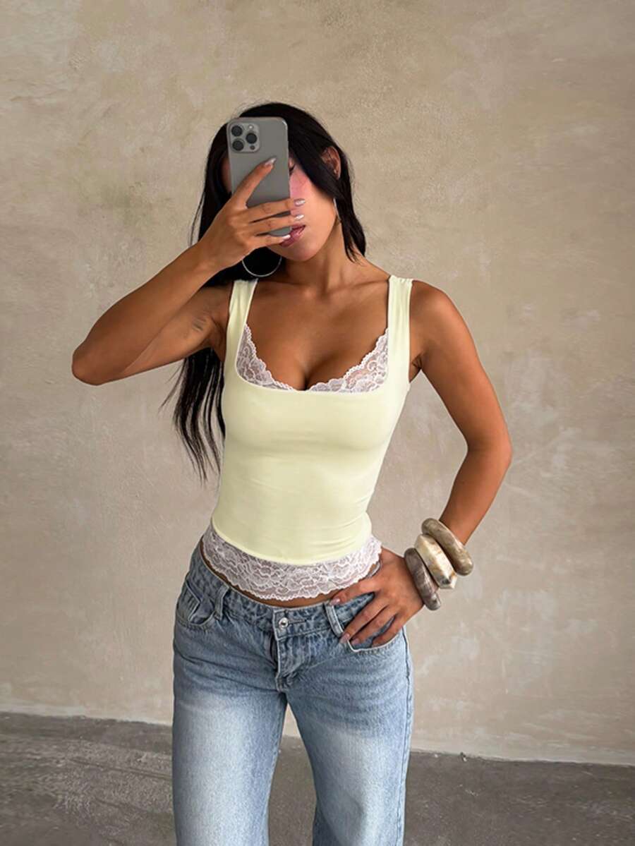 Women's white sleeveless crop top with contrast lace trim, shoulder straps, and a floral graphic print.