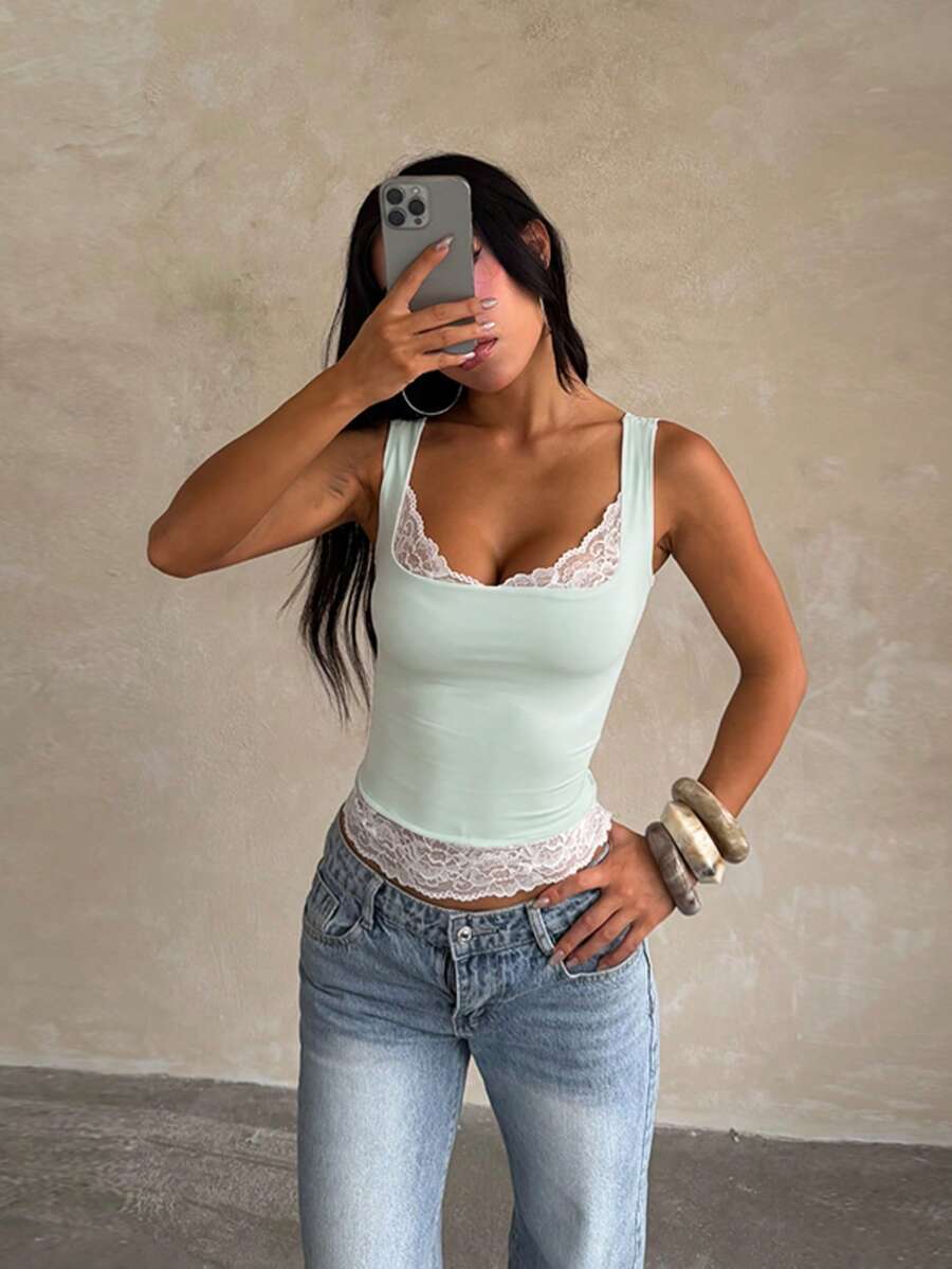Women's white sleeveless crop top with contrast lace trim, shoulder straps, and a floral graphic print.