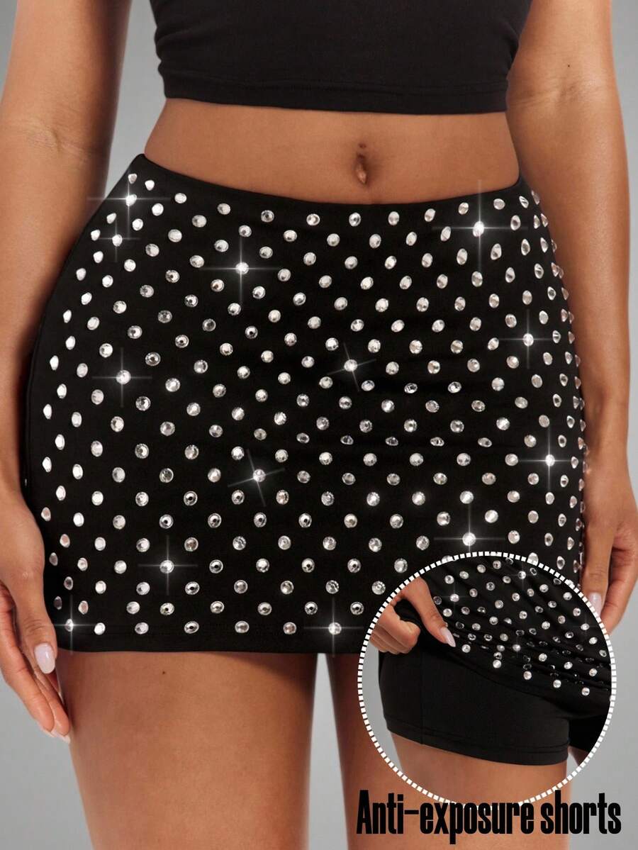 Women's black bodycon mini skort featuring a low waist, pleated side split hem, zipper closure, and built-in shorts.