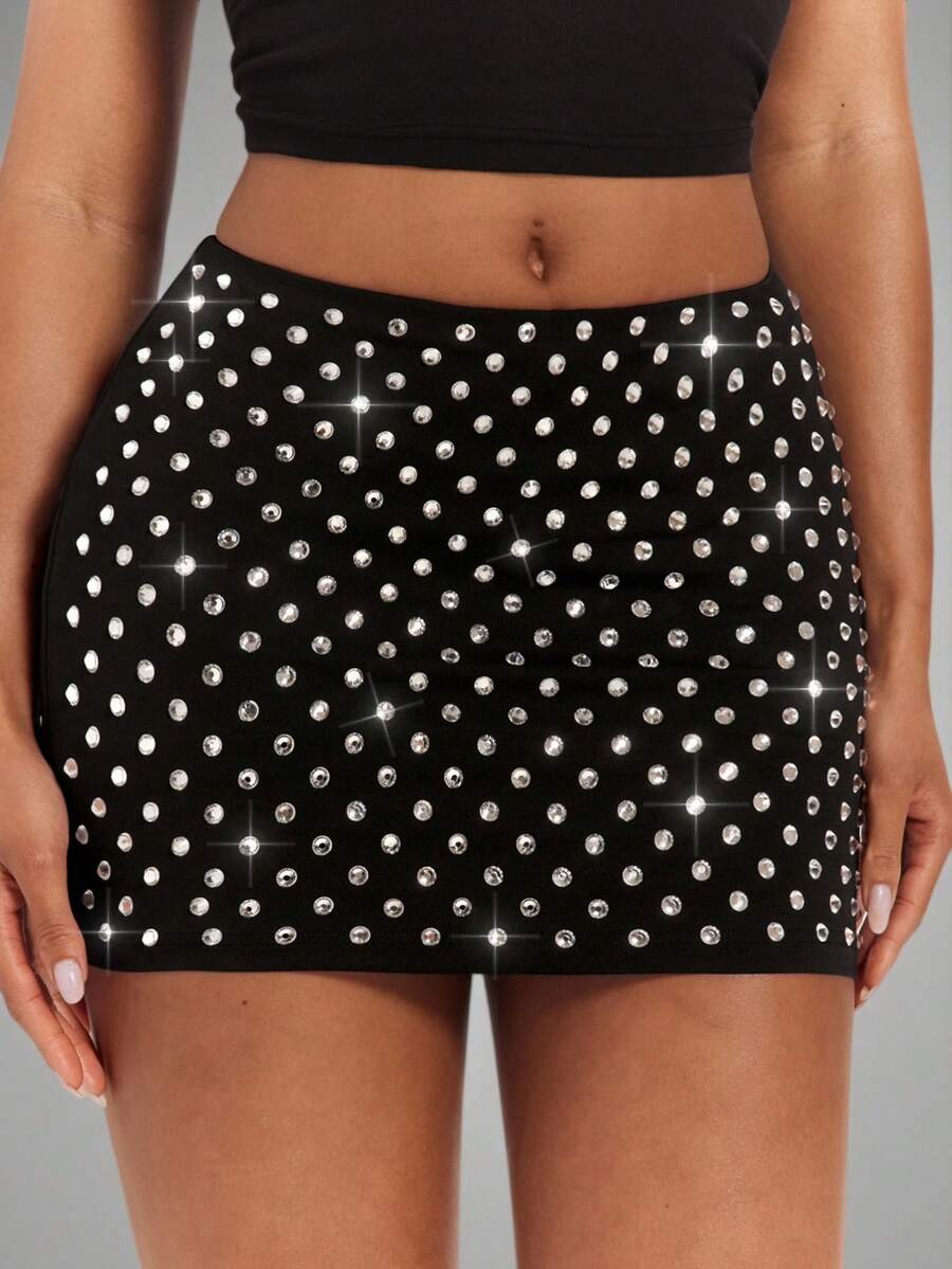 Women's black bodycon mini skort featuring a low waist, pleated side split hem, zipper closure, and built-in shorts.