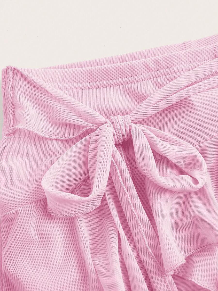 White tiered ruffle trim mini skirt for women with low waist, knot detail, mesh fabric, and casual Y2K boho design.