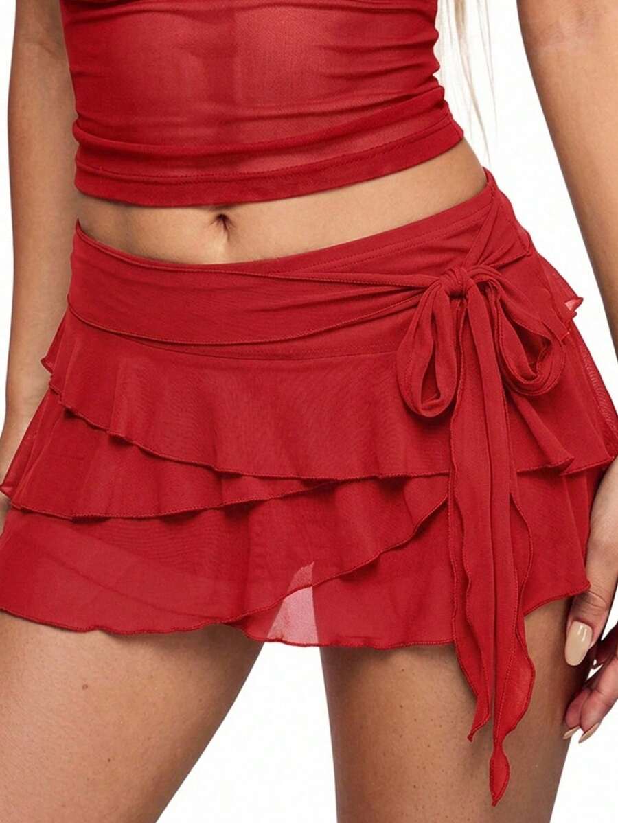 White tiered ruffle trim mini skirt for women with low waist, knot detail, mesh fabric, and casual Y2K boho design.