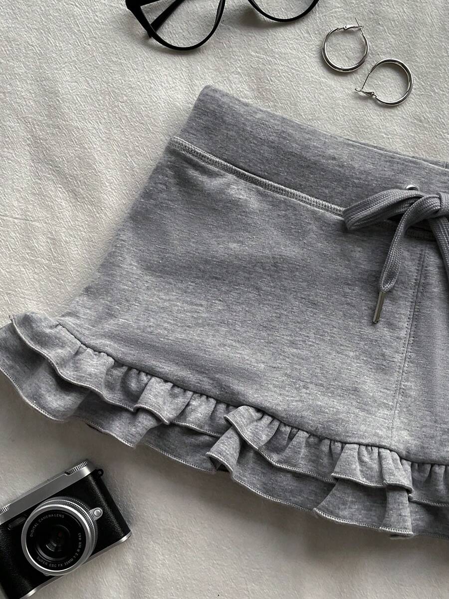 Women's plain black ultra low waist bodycon mini skirt with frill detailing in knitted stretch fabric.