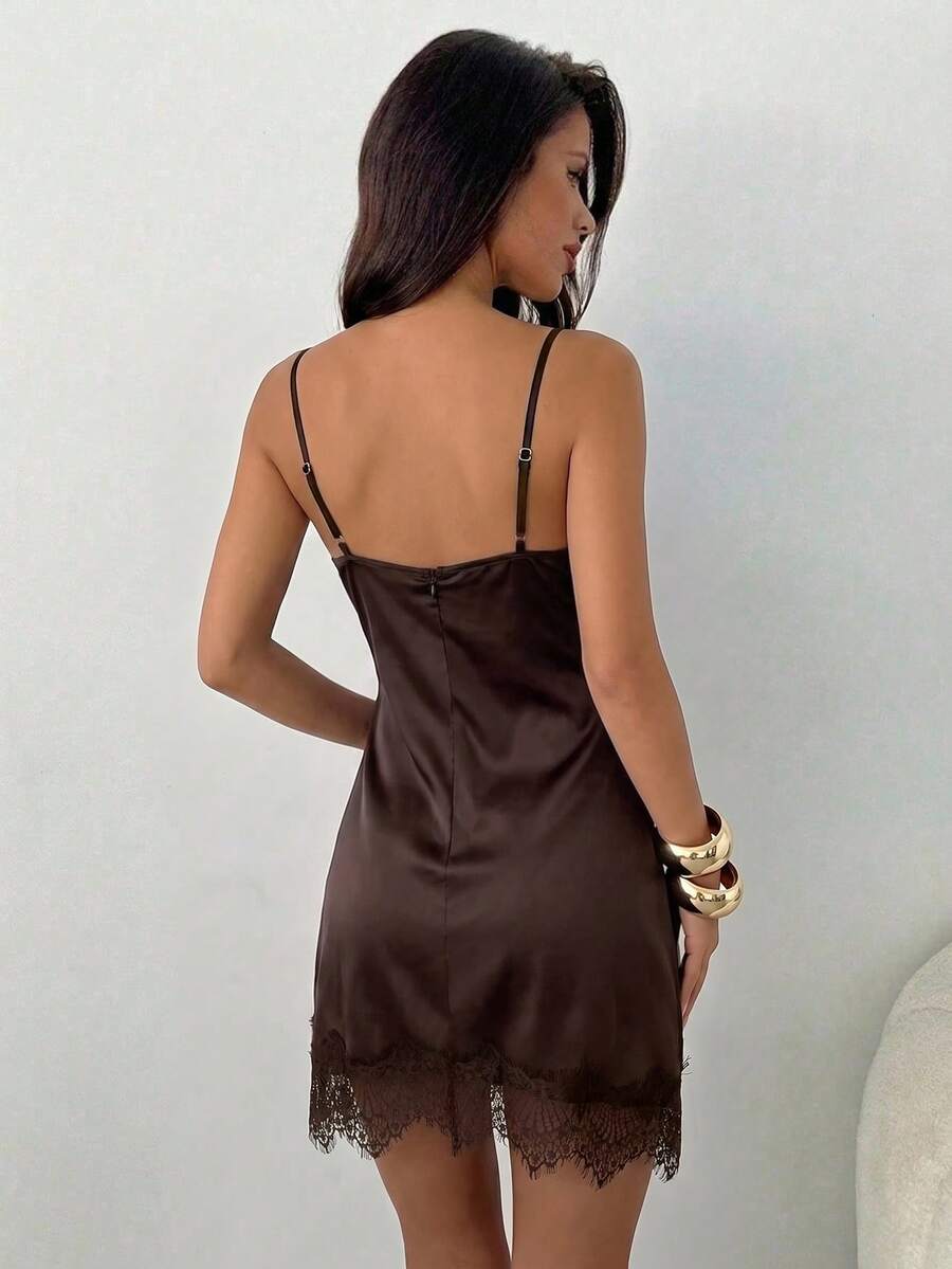 Black slim fit satin mini dress featuring contrast lace patchwork detail, spaghetti straps, and an asymmetrical hem for women.