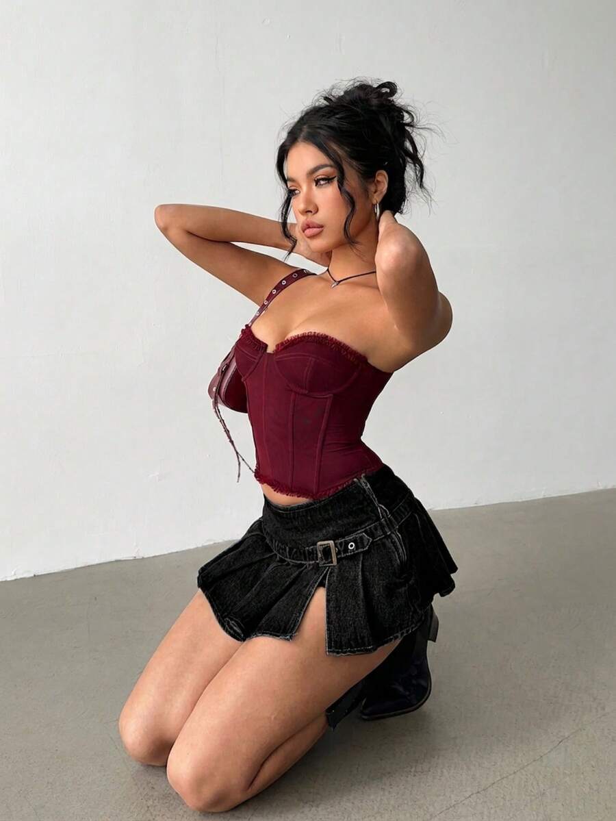 Women's blue denim pleated mini skirt skort featuring a low waist fit with zipper and grommet eyelet details.