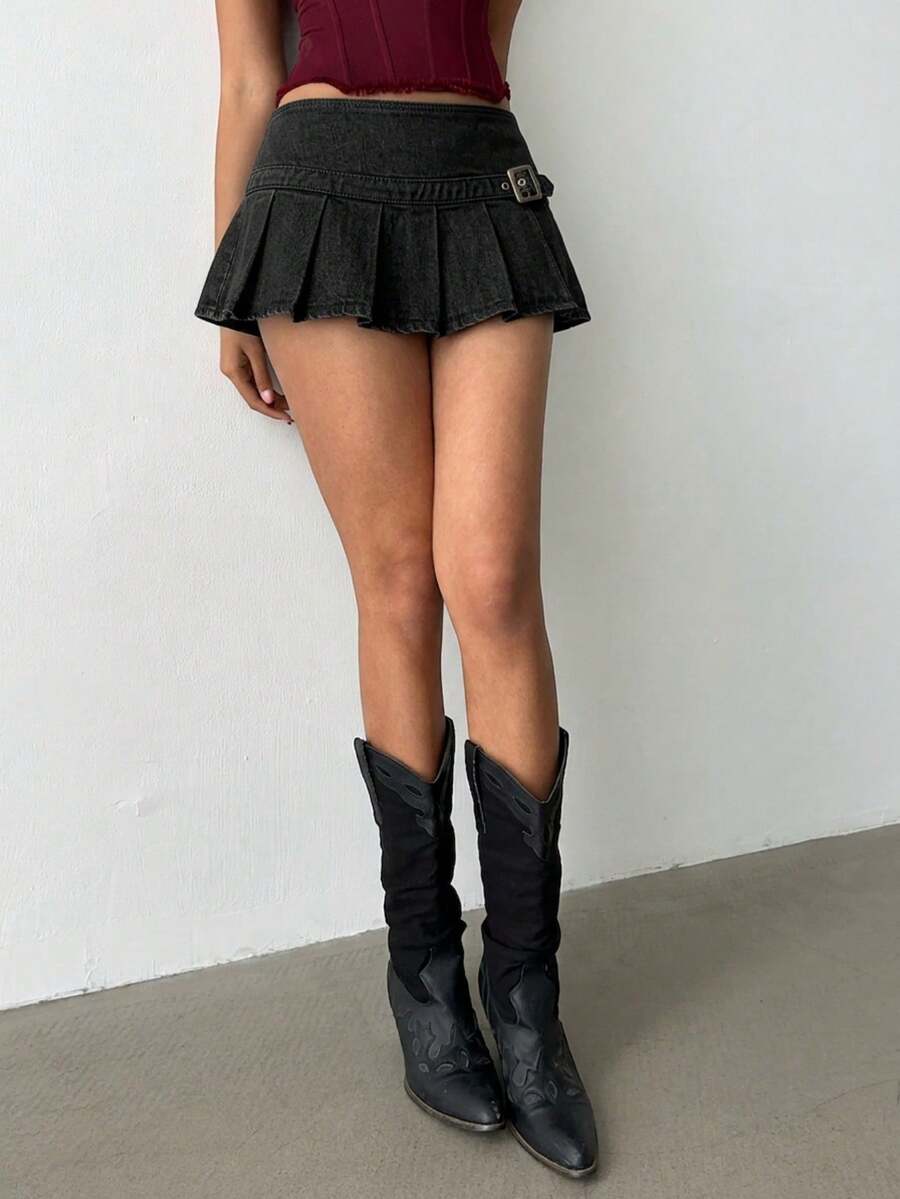 Women's blue denim pleated mini skirt skort featuring a low waist fit with zipper and grommet eyelet details.