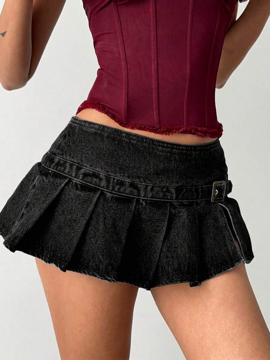 Women's blue denim pleated mini skirt skort featuring a low waist fit with zipper and grommet eyelet details.