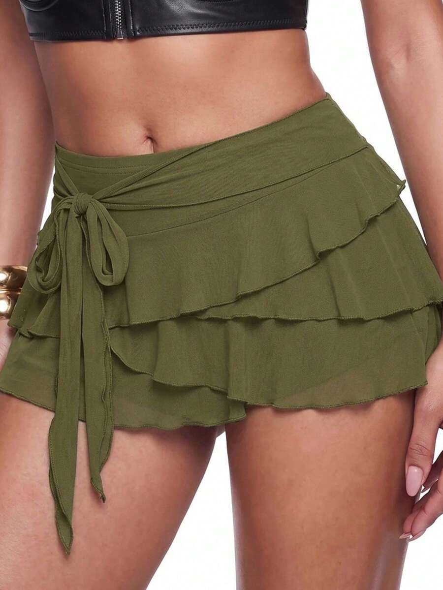 White tiered ruffle trim mini skirt for women with low waist, knot detail, mesh fabric, and casual Y2K boho design.