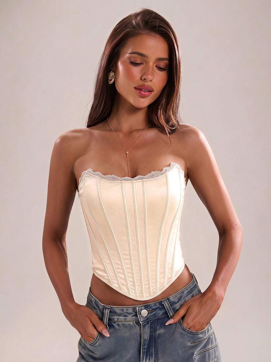 Women's strapless bustier crop top with contrast lace, lace-up detail, and an asymmetric hem in a slim-fit satin finish.
