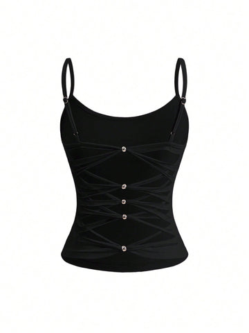 Woman wearing a black backless halter tank top with criss-cross details and textured knit fabric