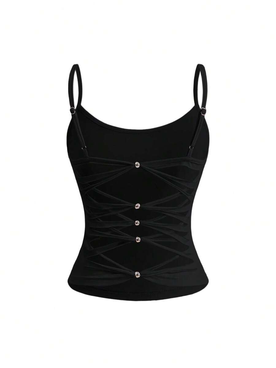 Woman wearing a black backless halter tank top with criss-cross details and textured knit fabric