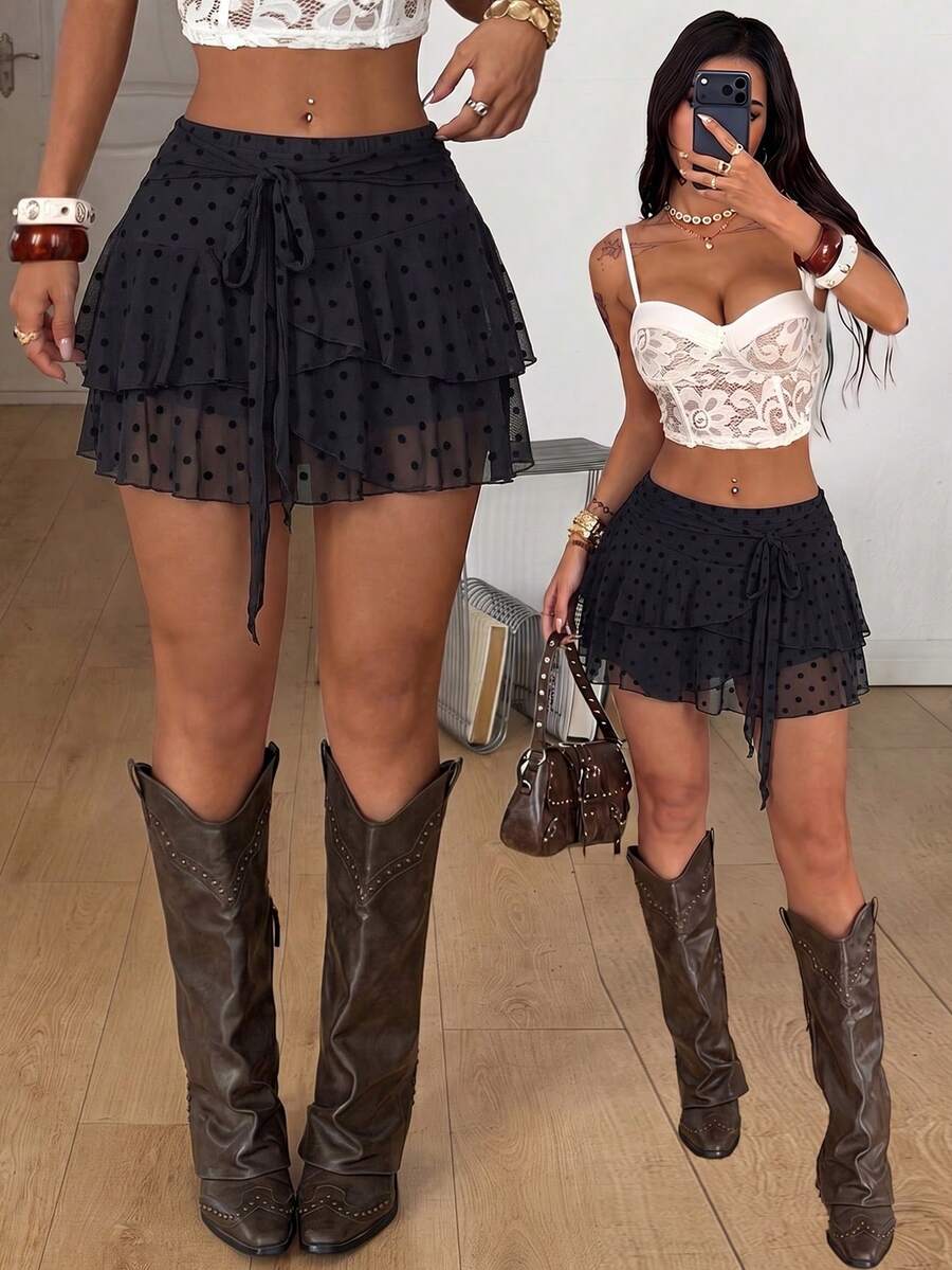 Black low waist tiered mini skirt featuring a ruffle hem and ring accent detail on knitted stretch fabric for women.