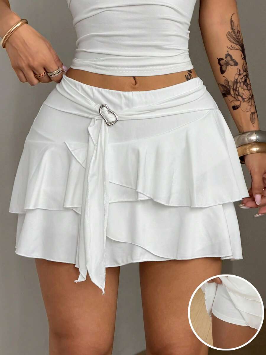 Black low waist tiered mini skirt featuring a ruffle hem and ring accent detail on knitted stretch fabric for women.
