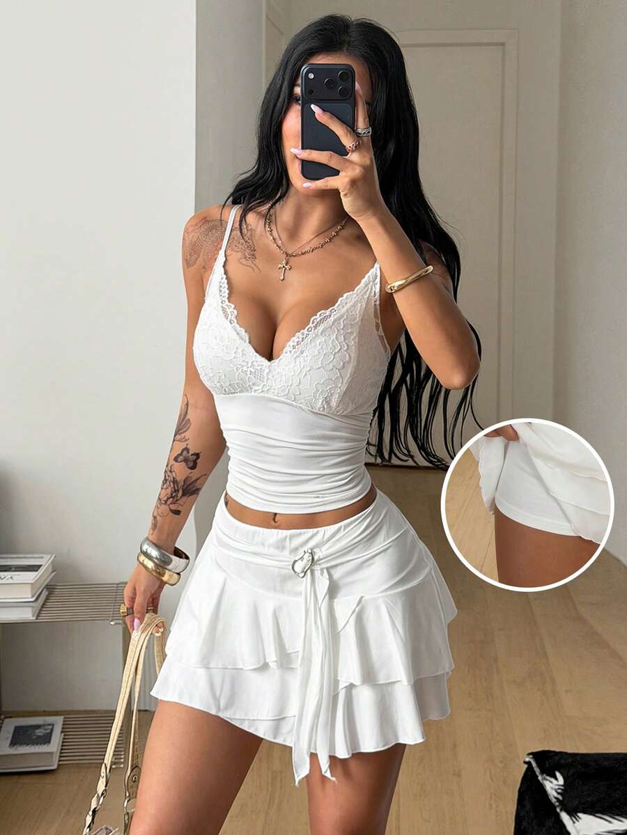 Black low waist tiered mini skirt featuring a ruffle hem and ring accent detail on knitted stretch fabric for women.