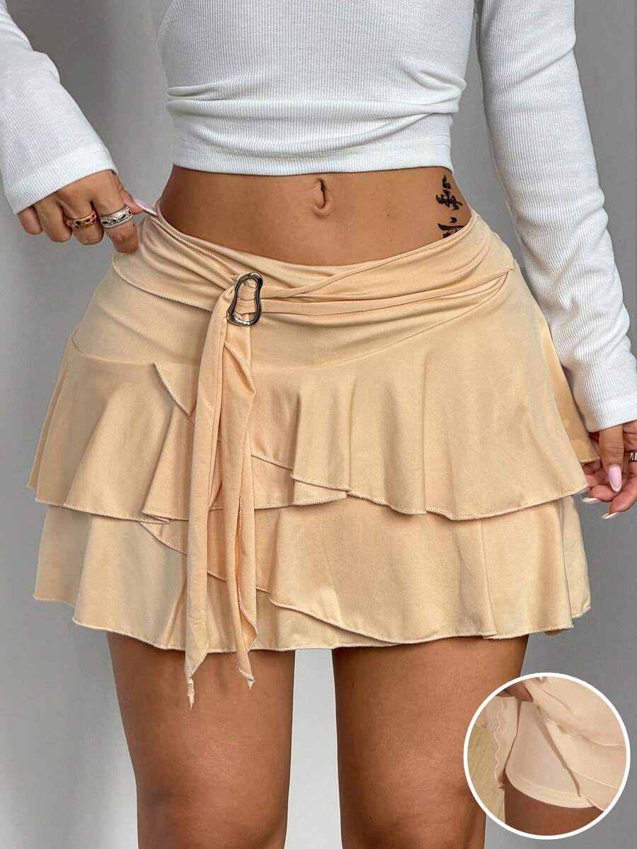 Black low waist tiered mini skirt featuring a ruffle hem and ring accent detail on knitted stretch fabric for women.