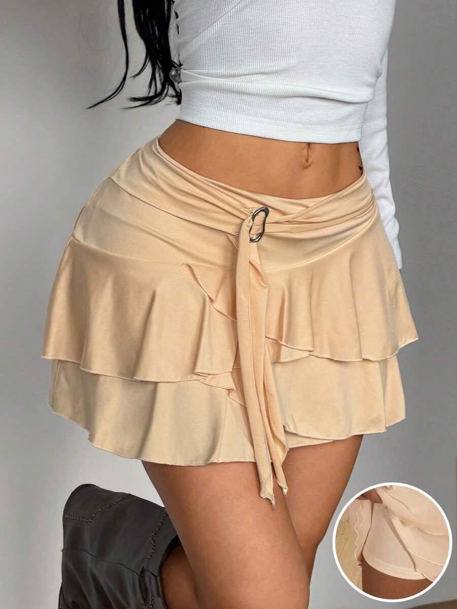Black low waist tiered mini skirt featuring a ruffle hem and ring accent detail on knitted stretch fabric for women.
