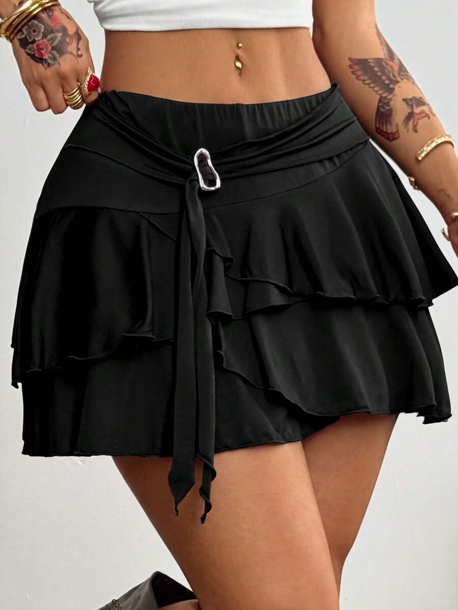 Black low waist tiered mini skirt featuring a ruffle hem and ring accent detail on knitted stretch fabric for women.