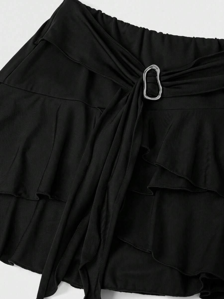 Black low waist tiered mini skirt featuring a ruffle hem and ring accent detail on knitted stretch fabric for women.