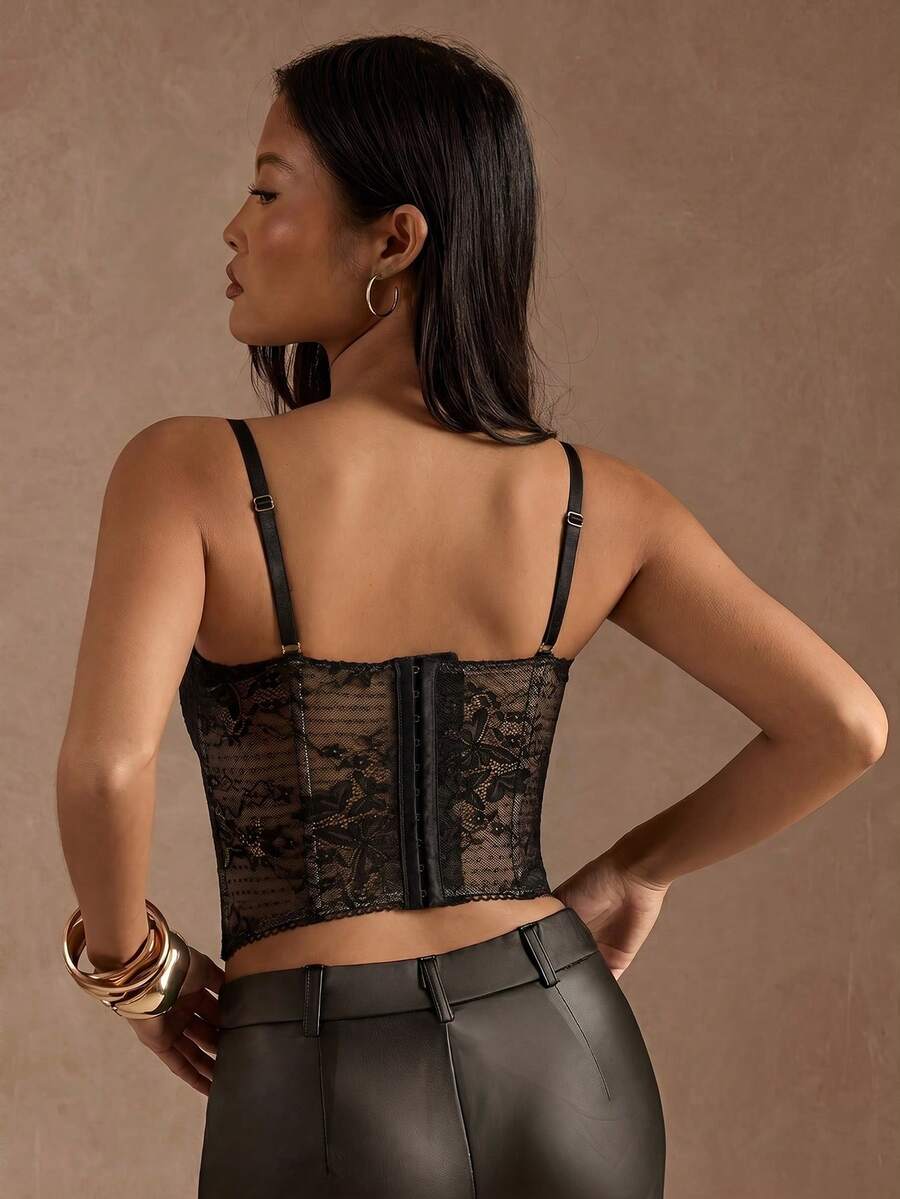 Black women’s lace cami top with spaghetti straps, contrast lace details, and an asymmetrical hem, styled as a slim-fit lined casual top.