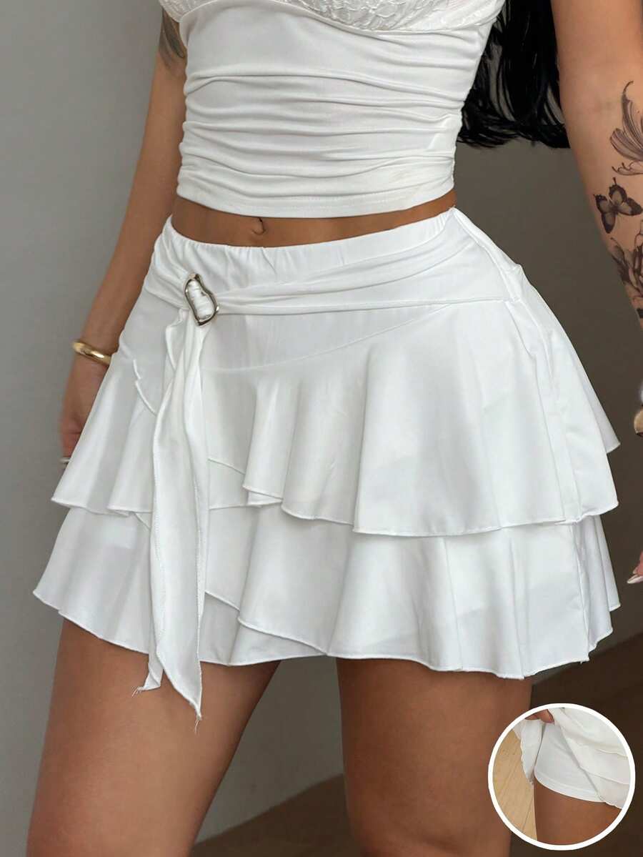 Black low waist tiered mini skirt featuring a ruffle hem and ring accent detail on knitted stretch fabric for women.