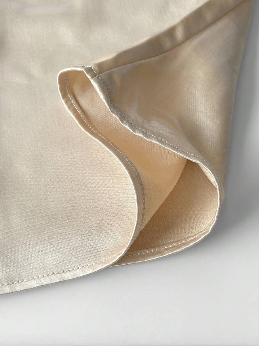 Women's woven spaghetti strap camisole with cup detail and cropped length in apricot.
