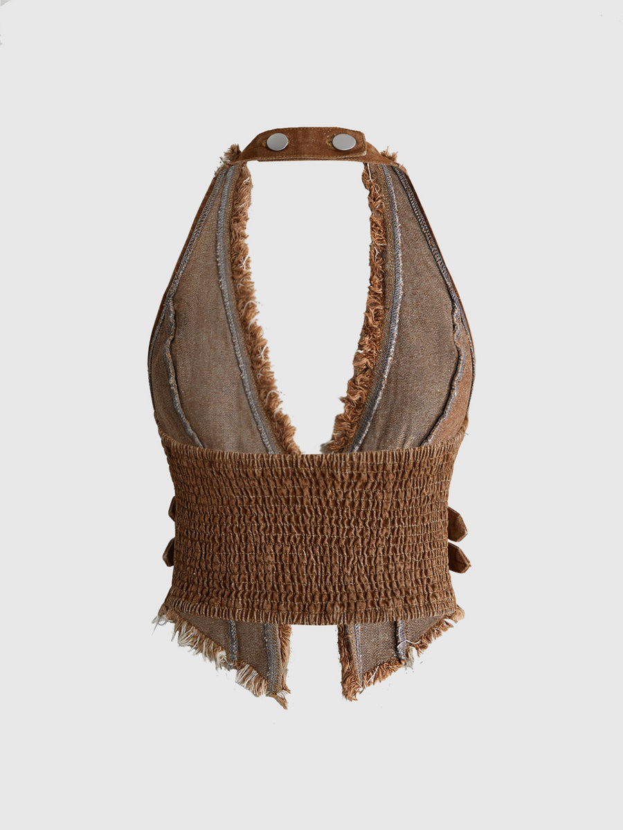 Women's denim halter crop top featuring a backless design, asymmetrical hem, single-breasted front, and lettuce trim.