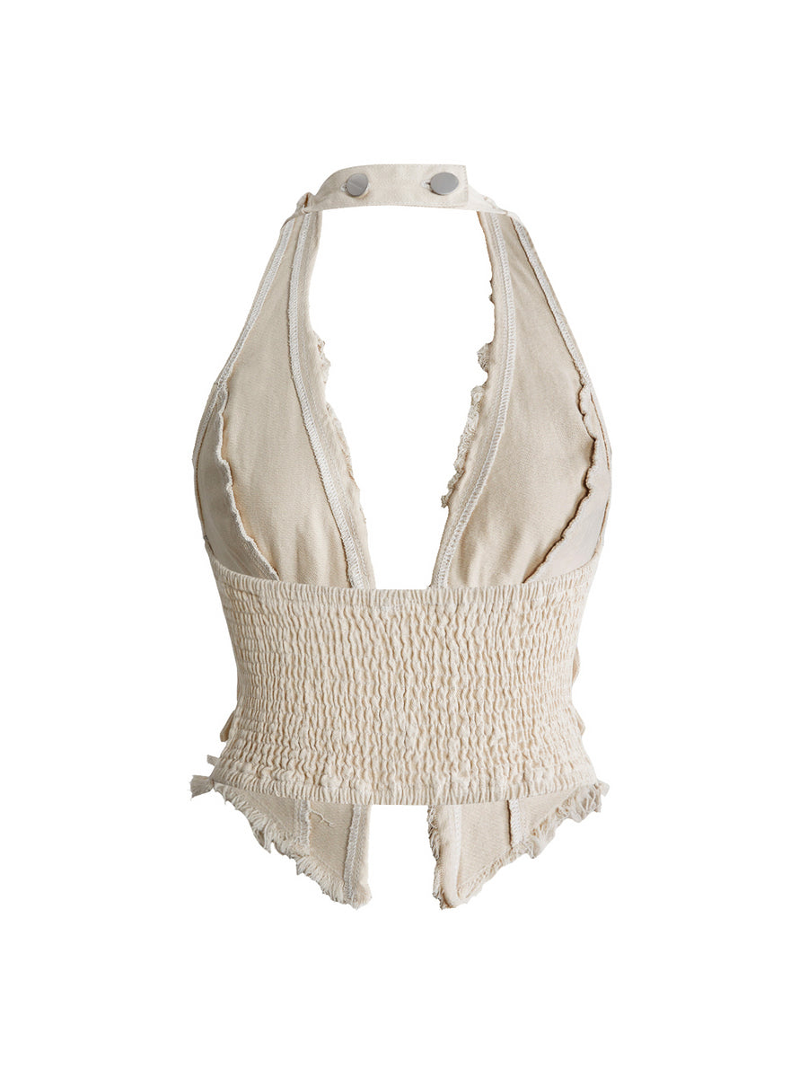 Women's denim halter crop top featuring a backless design, asymmetrical hem, single-breasted front, and lettuce trim.