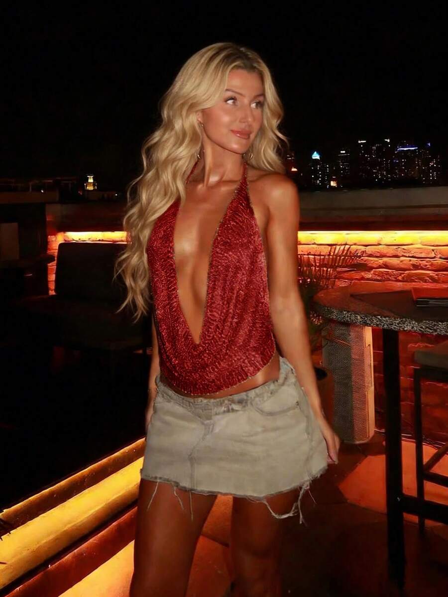 Women's cowl neck metallic knit tank top with thin spaghetti straps and a backless draped silhouette.