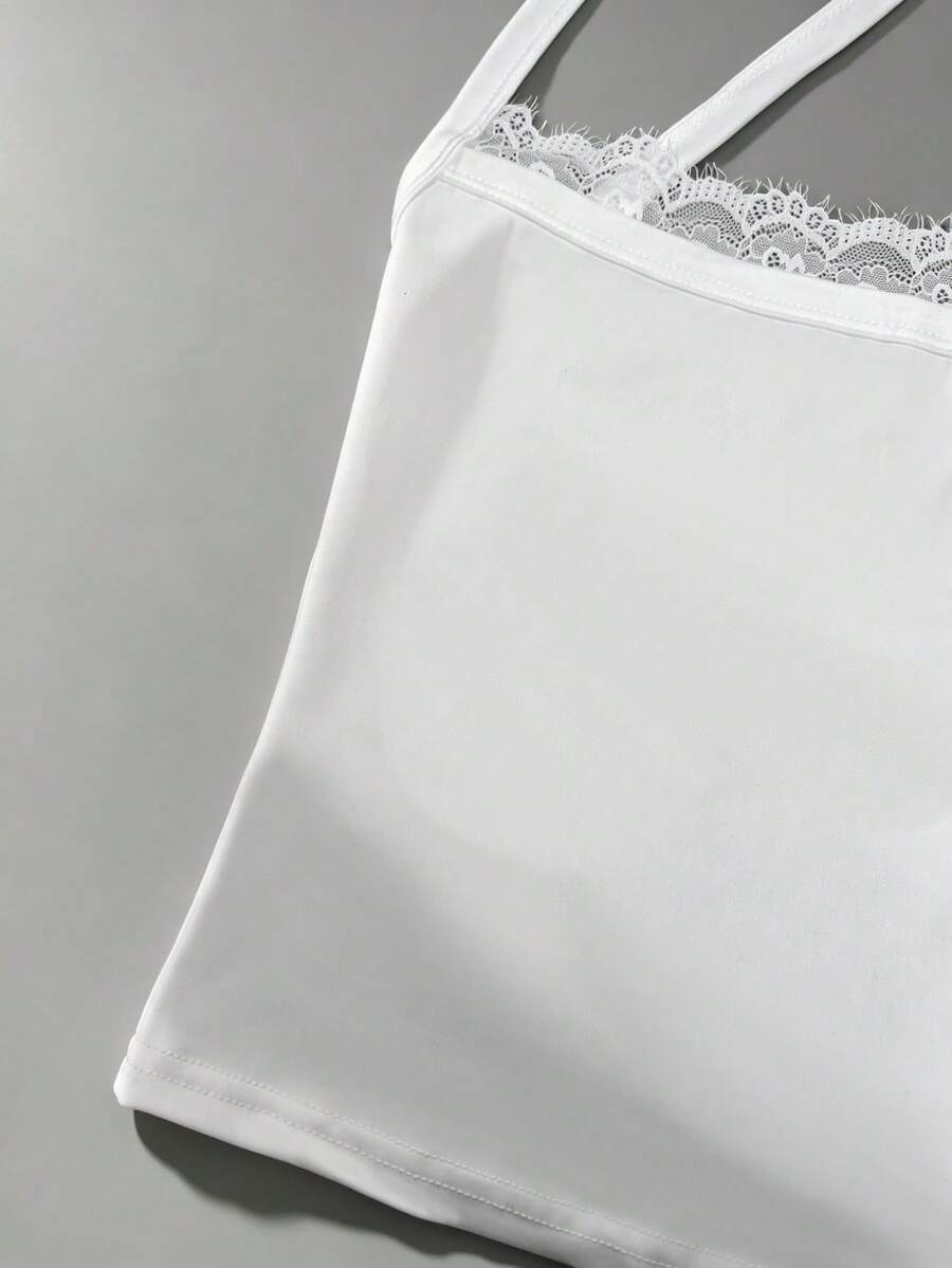 Women's white backless tank top featuring contrast lace details, criss-cross back straps, and wide shoulder straps.