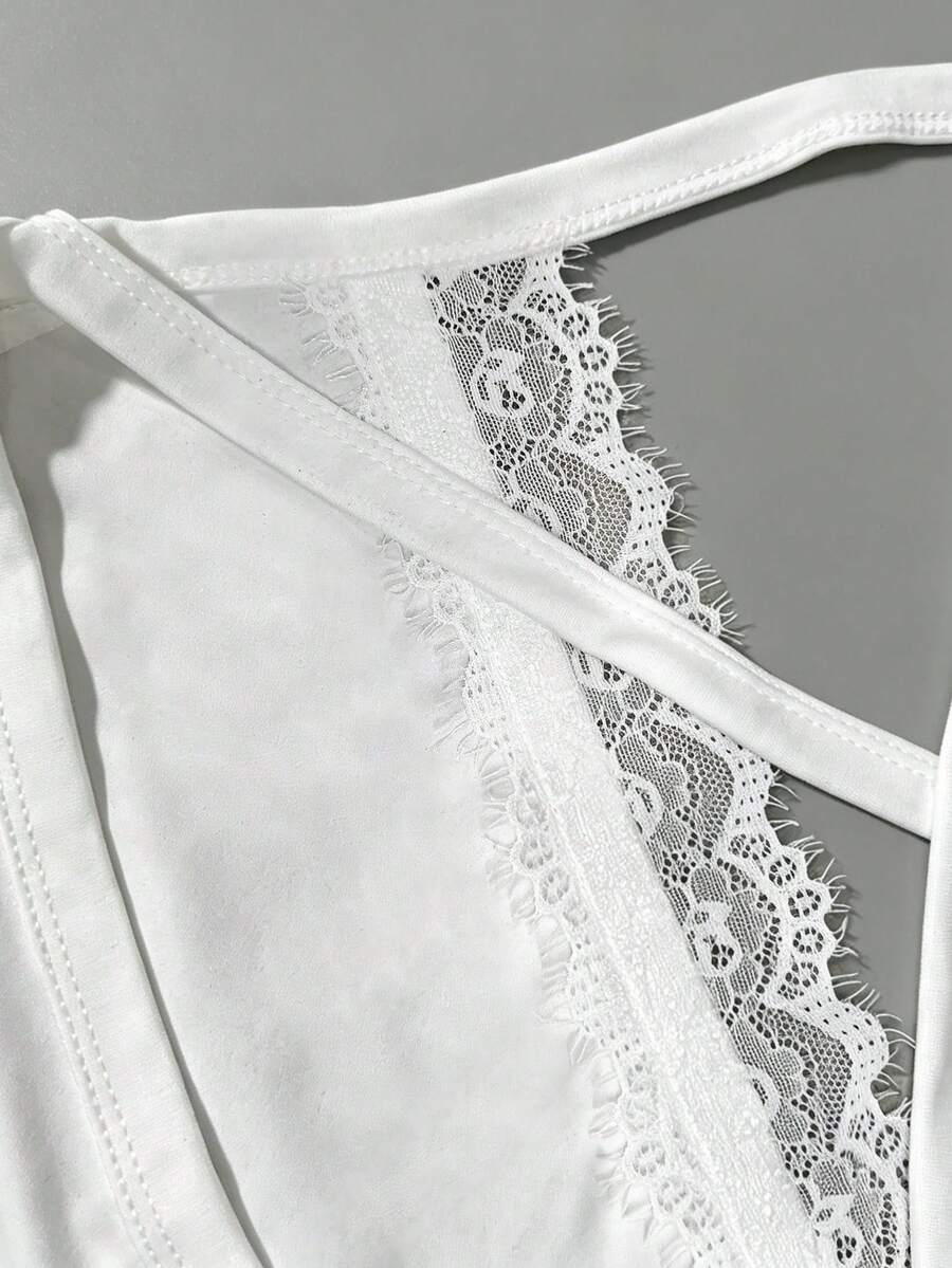 Women's white backless tank top featuring contrast lace details, criss-cross back straps, and wide shoulder straps.