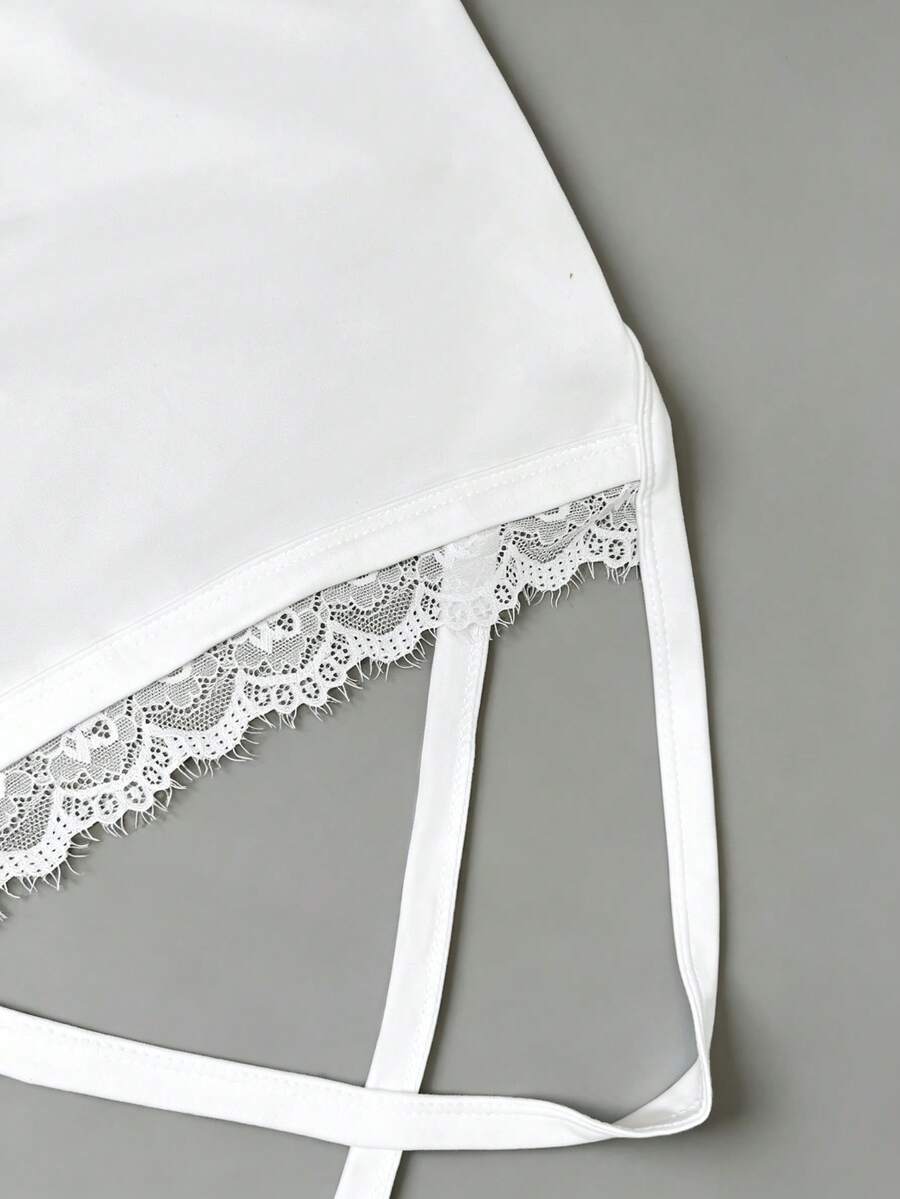 Women's white backless tank top featuring contrast lace details, criss-cross back straps, and wide shoulder straps.