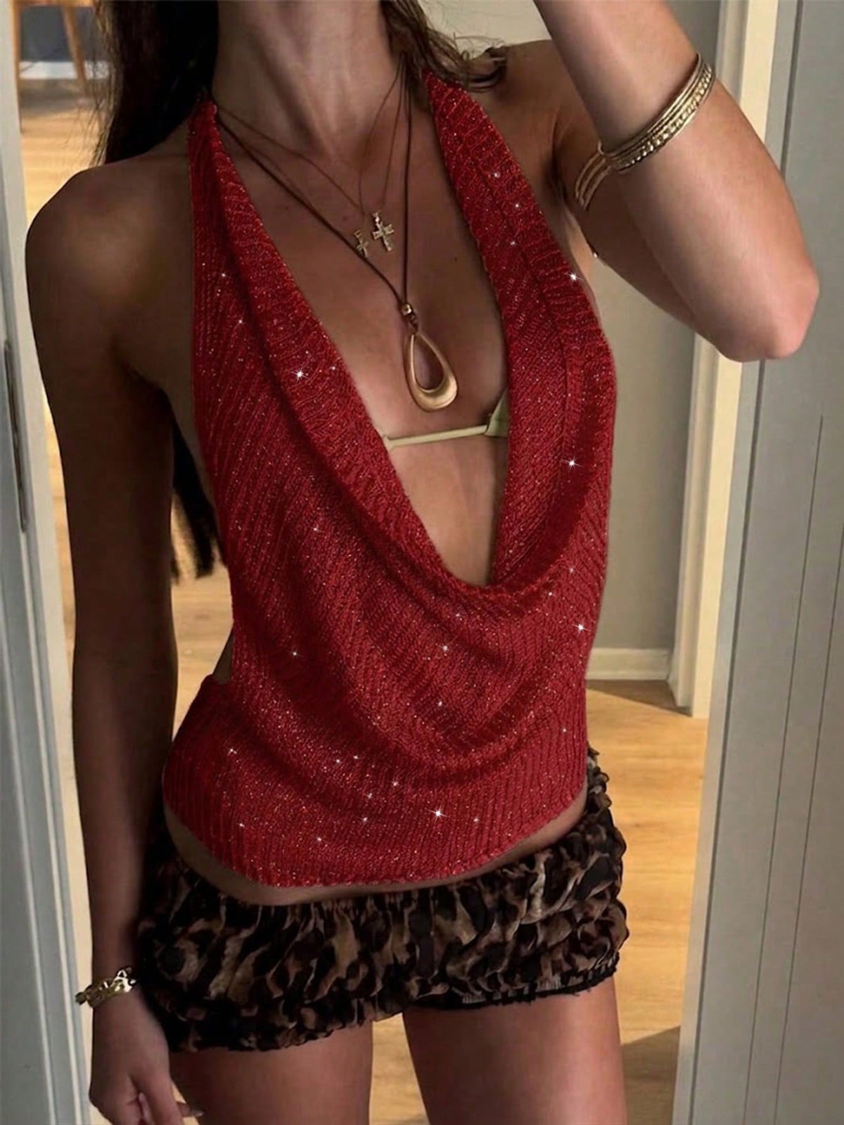 Women's cowl neck metallic knit tank top with thin spaghetti straps and a backless draped silhouette.