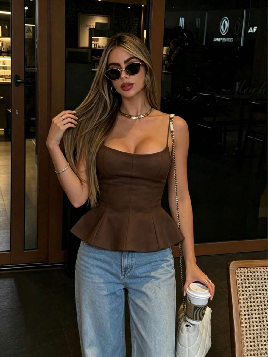 A sleeveless cropped camisole top featuring thin spaghetti straps, a slim fit bodice, and a subtle flared hemline.