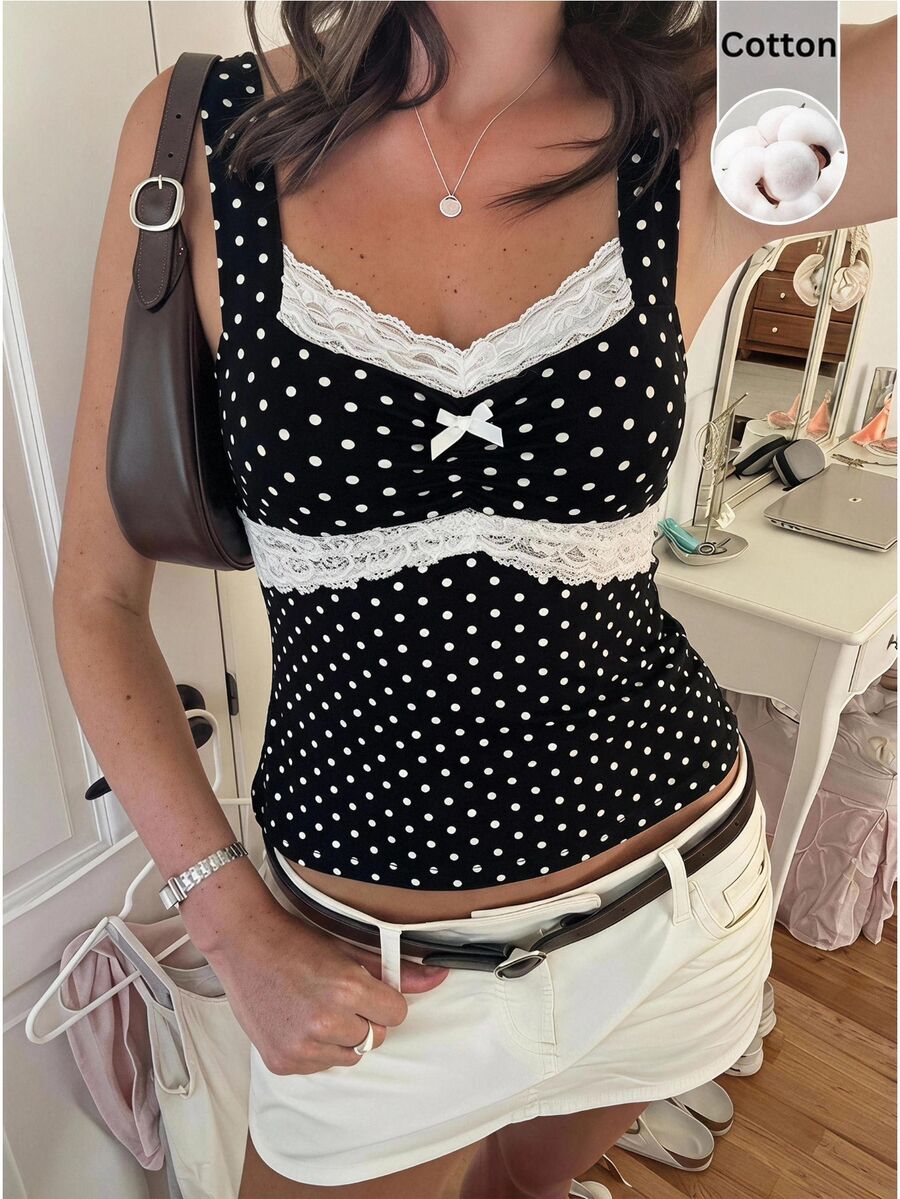 Black and white polka dot knit camisole tank top featuring delicate contrast lace trim, a cute bow accent at the sweetheart neckline, and slender shoulder straps.