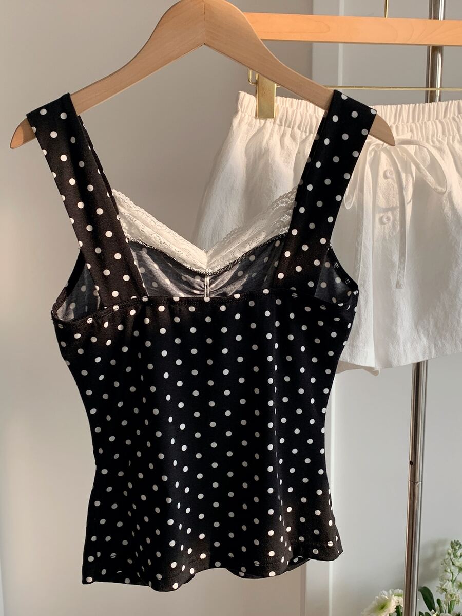 Black and white polka dot knit camisole tank top featuring delicate contrast lace trim, a cute bow accent at the sweetheart neckline, and slender shoulder straps.