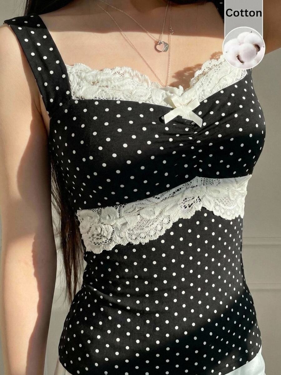 Black and white polka dot knit camisole tank top featuring delicate contrast lace trim, a cute bow accent at the sweetheart neckline, and slender shoulder straps.