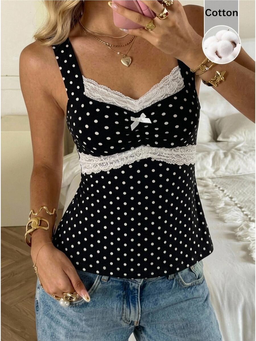 Black and white polka dot knit camisole tank top featuring delicate contrast lace trim, a cute bow accent at the sweetheart neckline, and slender shoulder straps.