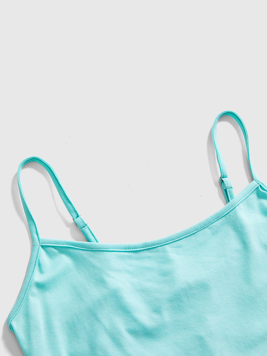 Woman wearing a black backless halter tank top with criss-cross details and textured knit fabric