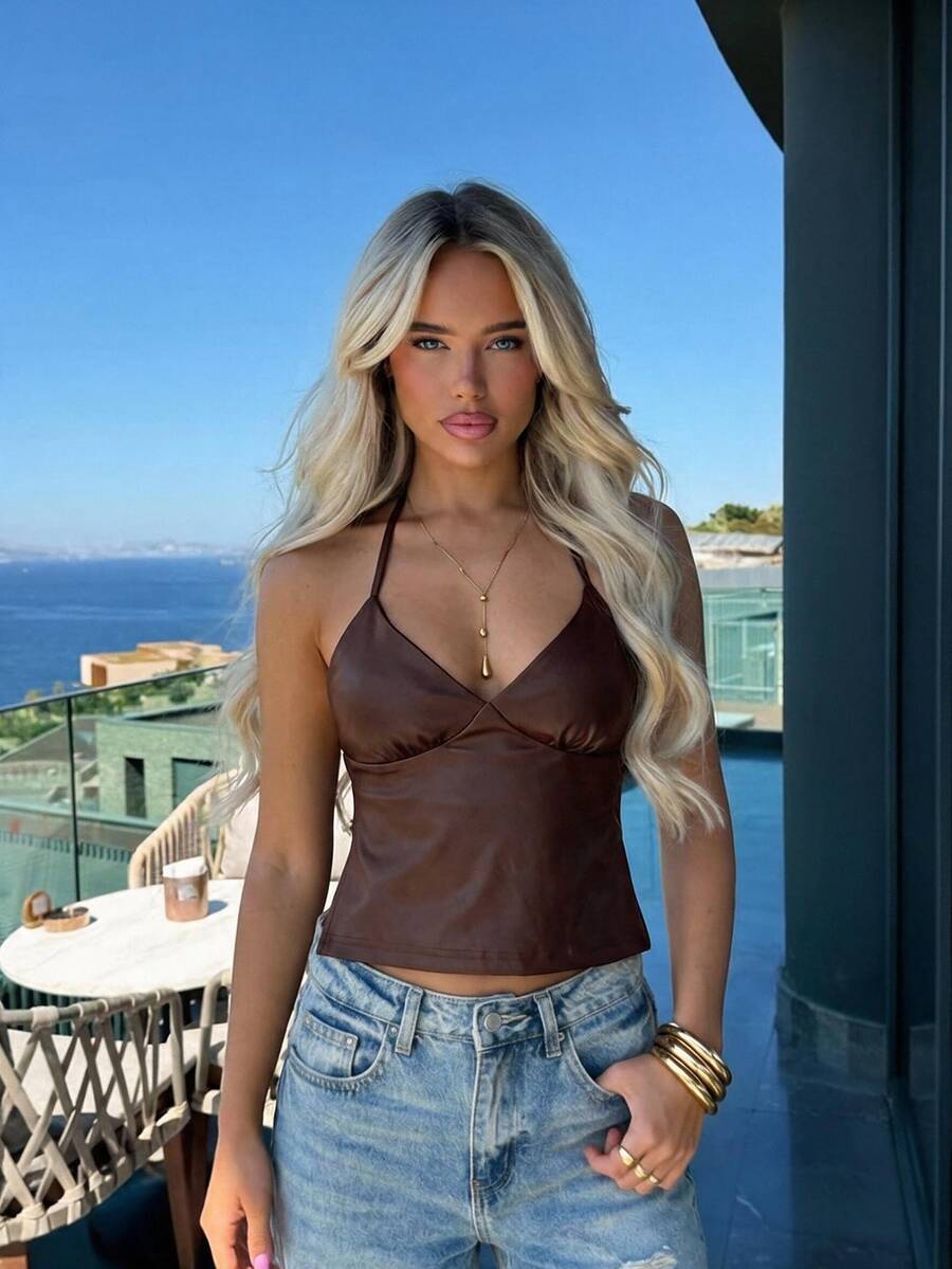 Women's black faux leather backless cami top with spaghetti straps and lace-up shirred sides.